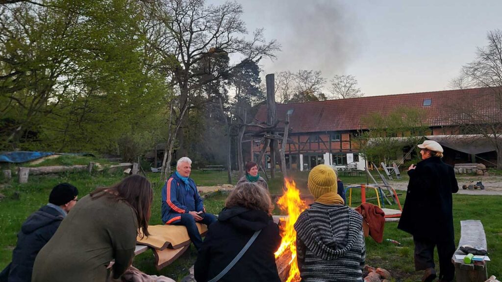 Menschen sitzen um ein Lagerfeuer herum